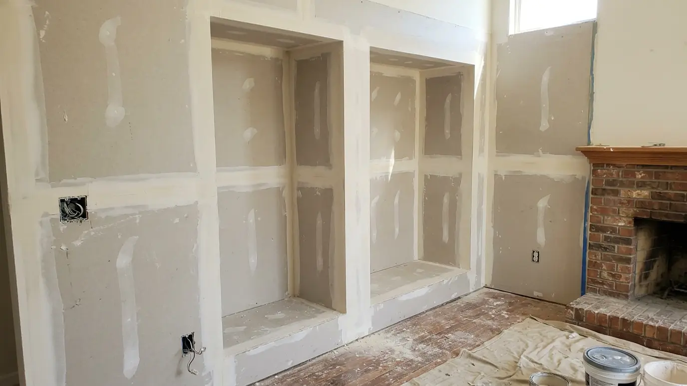 Before: a living room fireplace wall with bare drywall and empty alcoves beside the fireplace